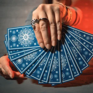 hand holding out an array of blue tarot cards