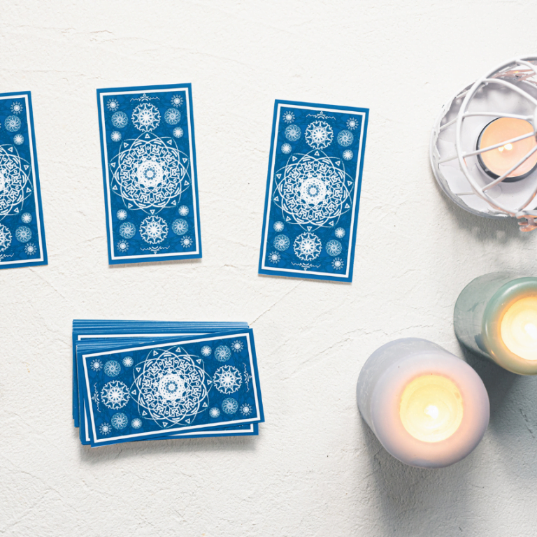 blue tarot cards spread on a white table covered in candles