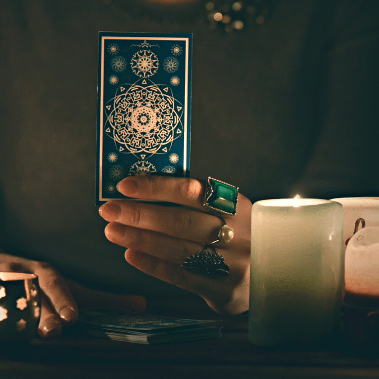 hand holding up a blue tarot card