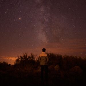 man starring at a pinky and purple starry sky