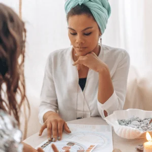 woman giving someone a reading using a birth chart
