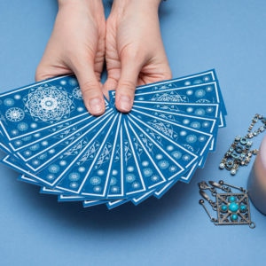 pair of hands holding out a spread of blue tarot cards