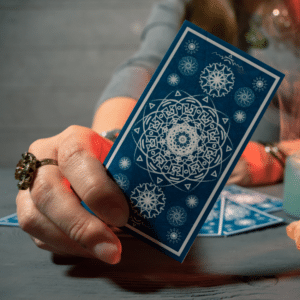 hand holding a blue tarot card