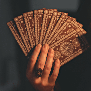 pair of hands holding up brown tarot cards