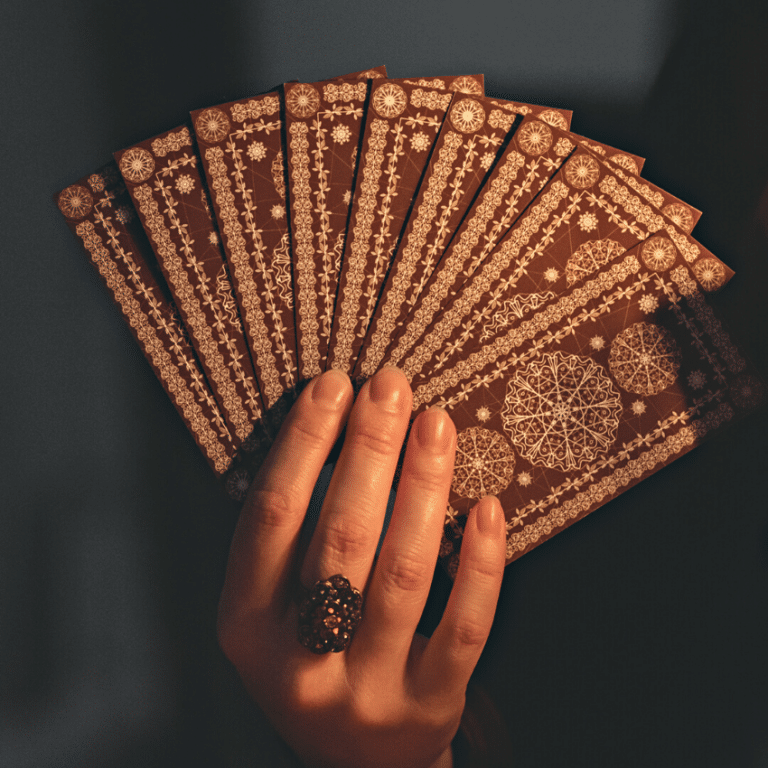 pair of hands holding up brown tarot cards