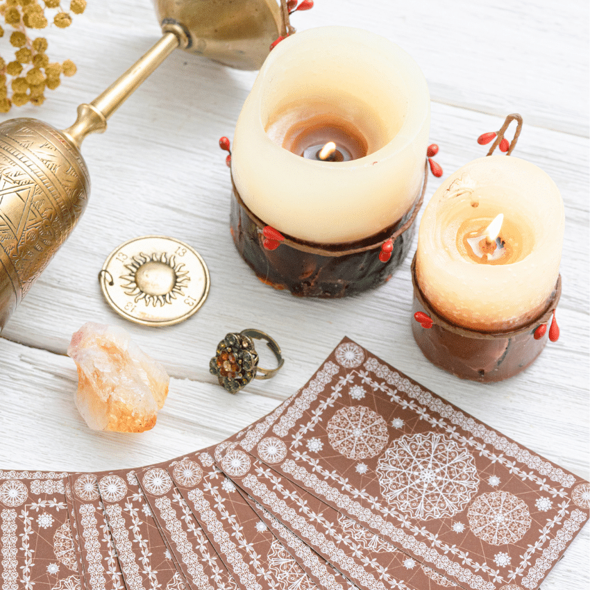 brown tarot cards spread out on a white table covered in candles