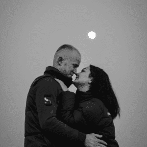 A couple embraces under a Full Moon