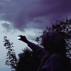 The dark outline of a person appears to be pinching the full moon in the sky to represent the lunar events happening in june 2025