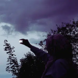 The dark outline of a person appears to be pinching the full moon in the sky to represent the lunar events happening in june 2025