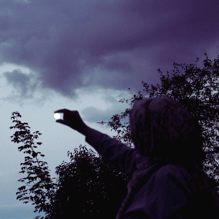 The dark outline of a person appears to be pinching the full moon in the sky to represent the lunar events happening in june 2025