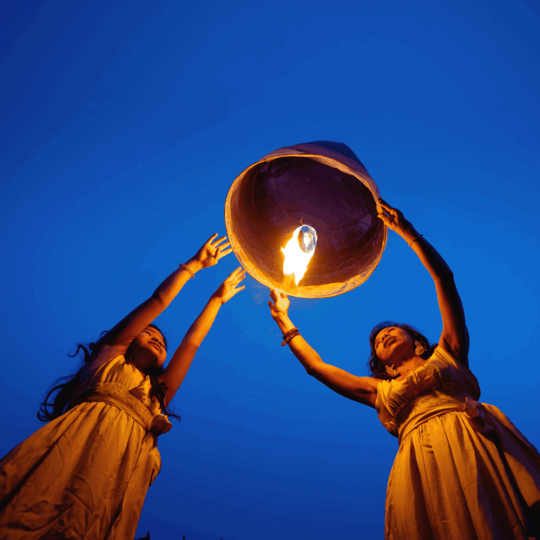 twin girls hold up a lantern ready to release it into the night sky