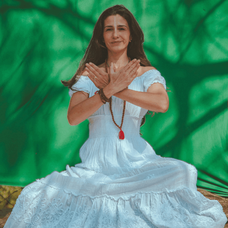 A brunette woman in a white dress holds her hands in front of her, ready to receive blessings from the Universe.