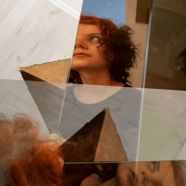A woman in a mirror is fragmented in an artistic way.