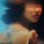 A blurred image of a woman with dark hair with half of her face underwater to represent the watery energy of Cancer.