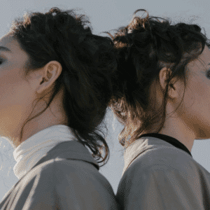 Twins stand back to back, their faces unseen, but the resemblance clear.