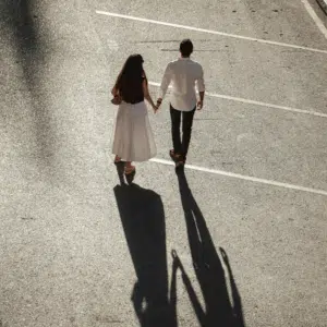 A far away photo of a couple holding hands.