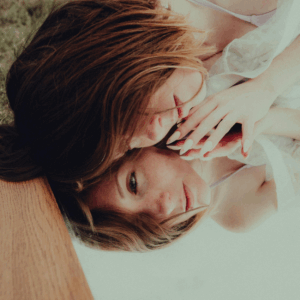 A woman lies on a mirror, showing her contemplative reflection back to her.