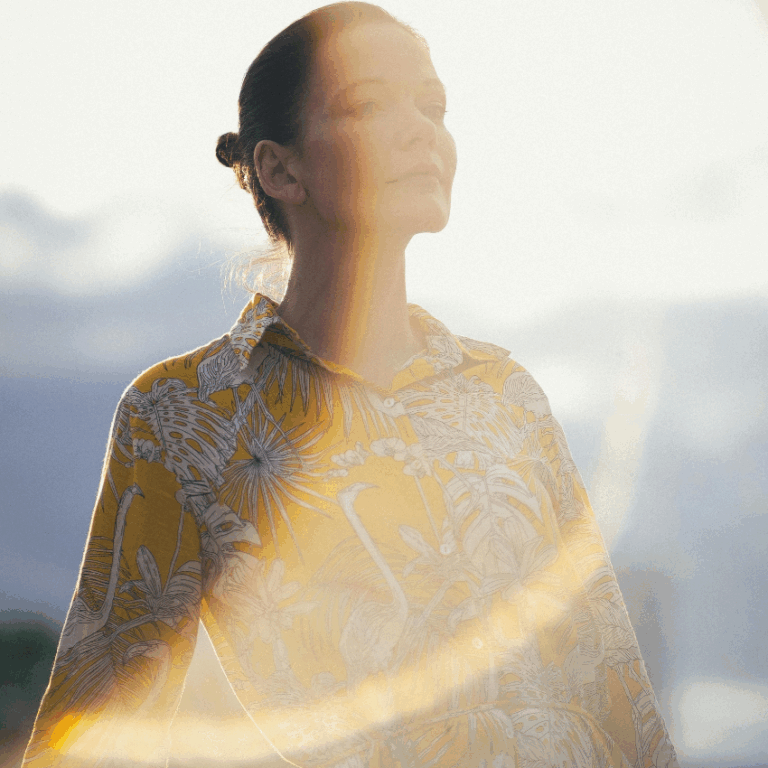 A woman stands with two sun circles overlapping her, representing the eclipses happening in September 2025.
