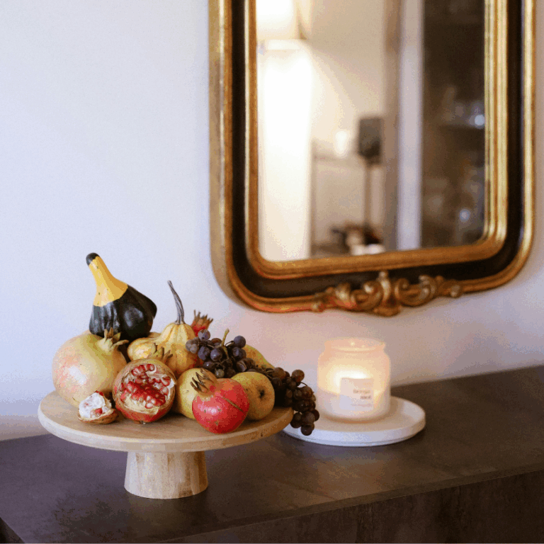 A tray of fruit, a candle, and a mirror all represent the types of abundance expected in November 2025.
