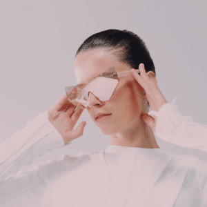 A woman wearing mirrored sunglasses looks down.