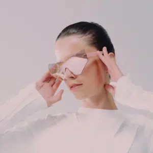 A woman wearing mirrored sunglasses looks down.