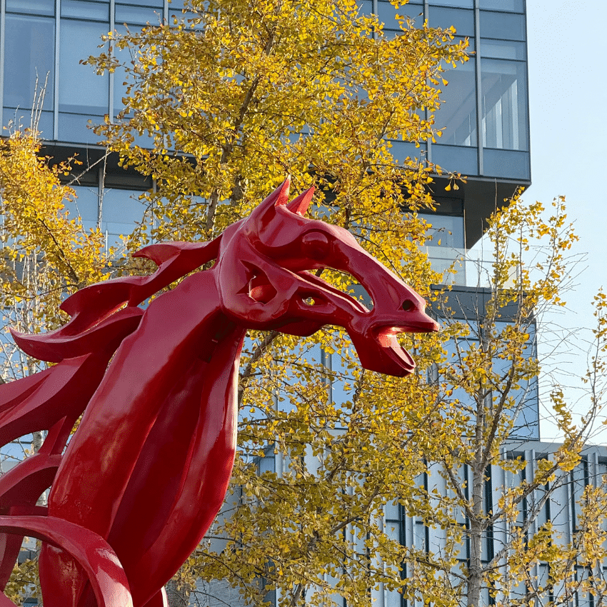 A red horse sculpture with a tree covered in yellow leaves to represent the year of the horse.