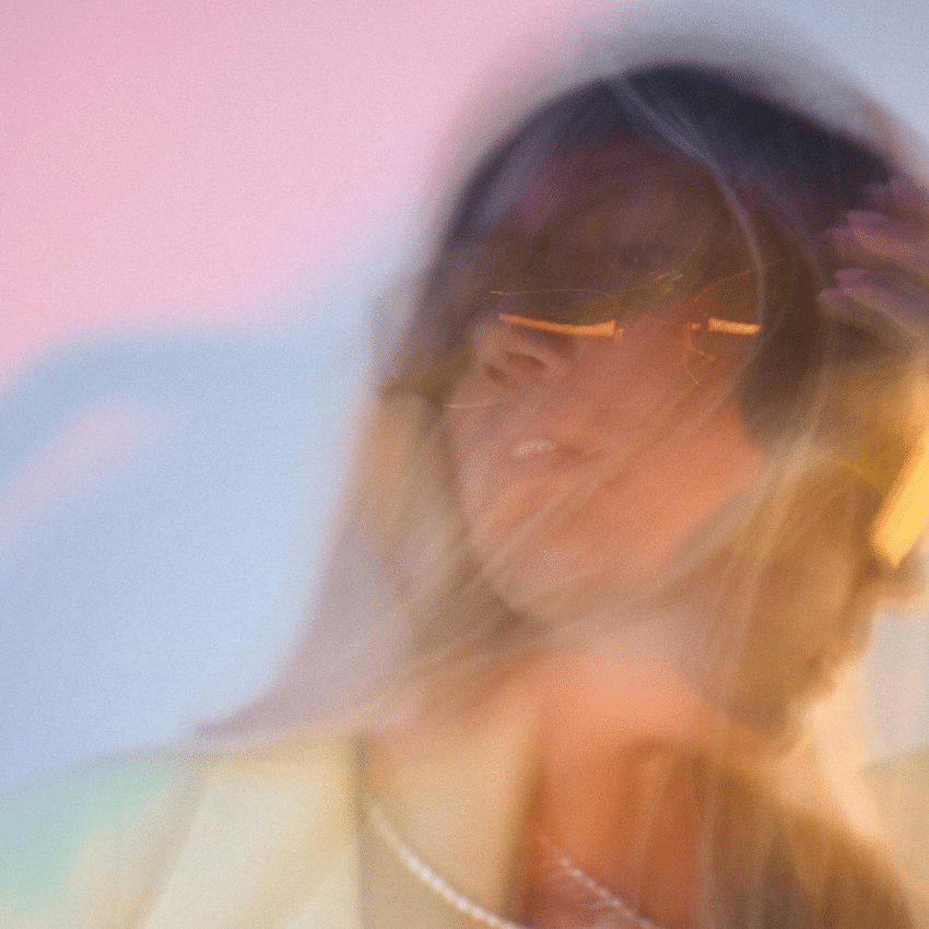 A double exposure of a woman with a sunset-coloured background to represent the energy of Jupiter going direct in Cancer.